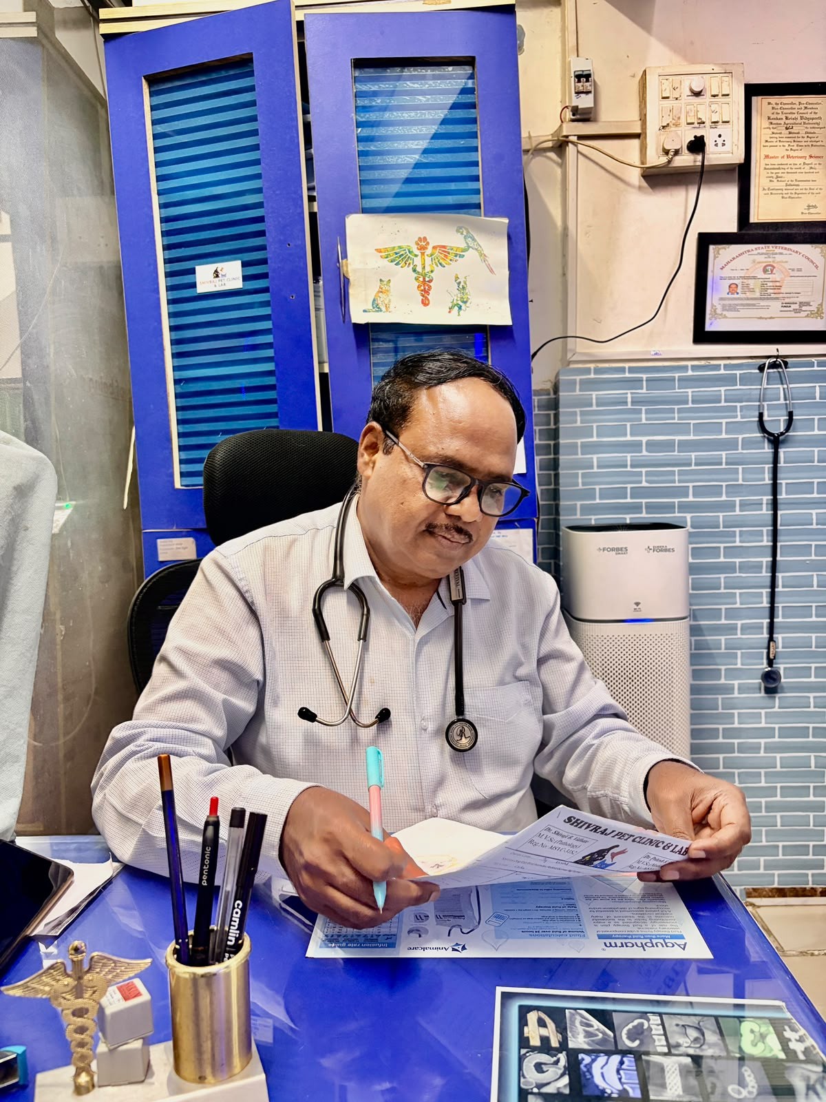 Dr. Shivaji Vidhate reviewing a patient record at Shivraj Pet Clinic, Pune